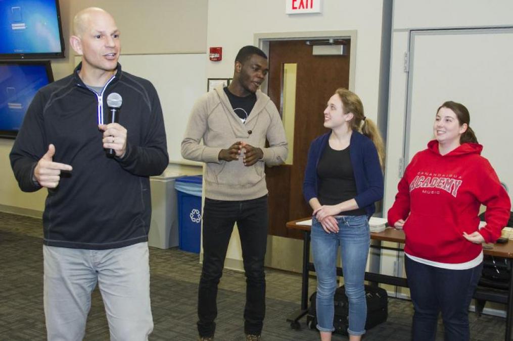 Graduates standing in front of a group of students talking to them