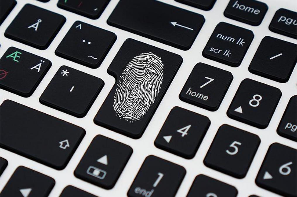 computer keyboard with a thumbprint on a key