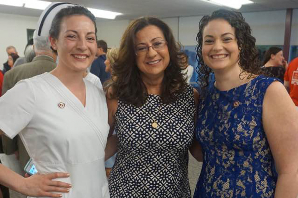 Nursing educator Edie Smith posing with two of her students on each side of her