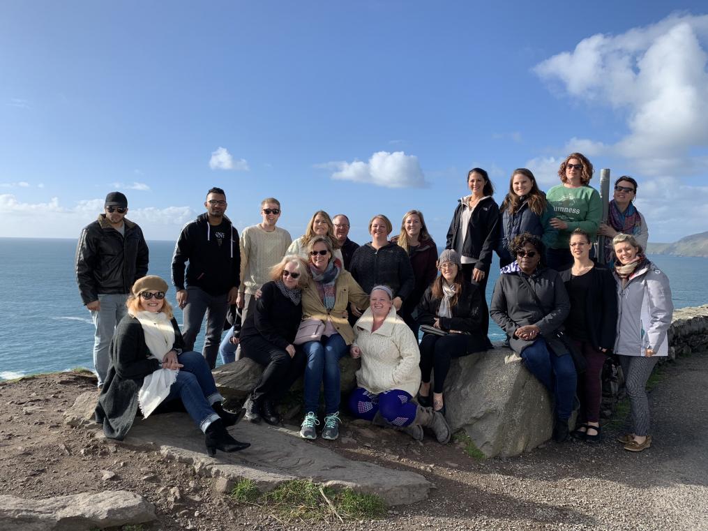 A group of nursing students stand by the ocean in Ireland.